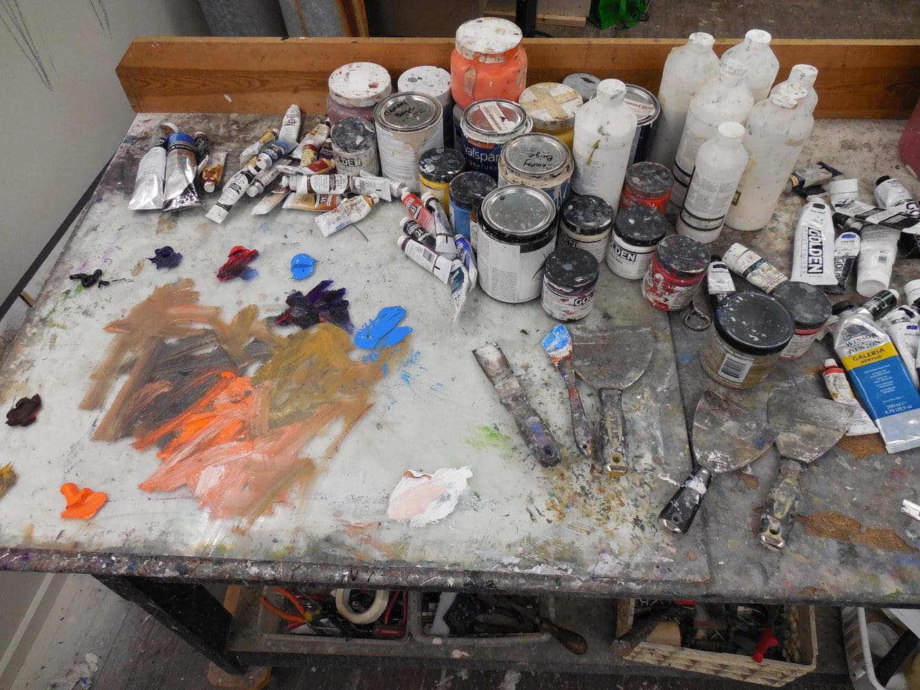 I come in everyday to my studio. I have a moderate 500 square foot space with cathedral ceilings about 12ft high. I have a long wall that I painted a mural on. I have a box that I built on rollers which can handle a lot of the taller pieces. It’s a very physical work space. I have palate knives that I get from Home Depot or Lowes. I buy a lot of the tools from hardware stores. When people look at my work they can feel how physical it is. Very labor intensive projects that relay on a lot of different materials. I do 6 to 8 paintings at a time. I like to walk a semi-circle around my work. I want to have something to catch the viewer from every angle. I adjust things through this process. I want it to be enjoyed from all perspectives rather than just the face. In a lot of ways my paintings are sculptural